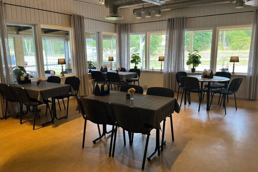 Ljus matsal med dukade bord och stora fönster
