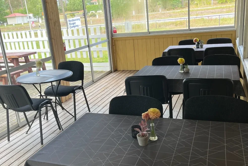Inglasad servering med svarta bord och blommor
